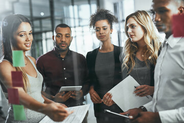 Wall Mural - Chasing the next big idea in business. Shot of a group of young businesspeople brainstorming in a modern office.