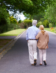 Wall Mural - Theyre lost in a world of their own. Rearview shot of senior couple taking a walk together.