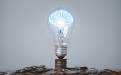 Wall Mural - Glowing virtual brain inside lightbulb on coin stacking for creative thinking idea and innovation can make more money concept.