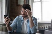 Concerned Annoyed Smartphone User Man Staring At Cellphone Screen With Upset Face, Having Problems With Online App, Banking Service, Getting Bad News, Feeling Stress About Poor Connection