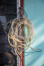 An Old Transparent Garden Hose And Wire Hang On A House Window