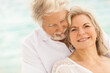 © Spotmatik - Carefree Caucasian senior couple in white clothes on a travel resort beach