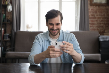 Wall Mural - happy cheerful freelance business professional using online app on smartphone at home office work ta