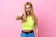 © luismolinero - Young Uruguayan blonde woman over isolated pink background frustrated and pointing to the front