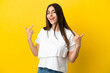 © luismolinero - Young caucasian woman isolated on yellow background giving a thumbs up gesture