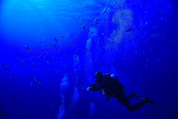 divers underwater at depth in the blue sea background