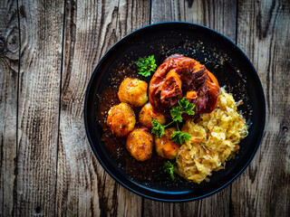 Sticker - Roast pork knuckle with potatoes and fried cabbage   on wooden table
