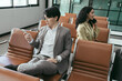 © chachamp - Businessman and businesswoman use smartphone at room in the airport