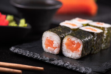 Wall Mural - Tasty maki rolls with salmon on a black slave stone