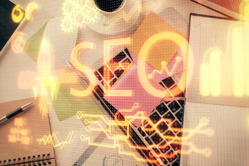 Double exposure of SEO drawing over study table background with computer. Concept of search. Top view.