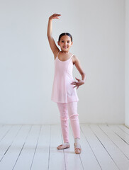 Sticker - Her self confidence grows through ballet. Portrait of a little girl practicing ballet in a dance studio.