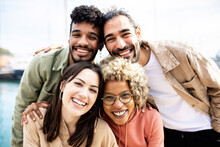 Group Portrait Of Four Multiracial United Friends Outdoors - Friendship Concept With Millennial Guys And Girls Enjoying Day Out On City Street - Focus On Women Face
