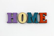Word home written with colorful wooden letters on white surface

