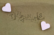 Word thanks made with letter stamps with two pink sugar hearts

