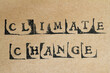 Word climate change made with letter stamps on grey hand made paper
