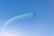 © aapsky - Silhouette of an airplane performing acrobatic flight on blue sky. Trace of smoke behind.