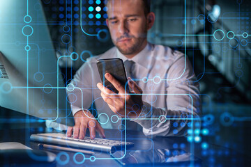 Businessman in casual wear using smart phone to optimize development by implying new technologies in business process. Interconnections and hi tech hologram over modern office background at night time
