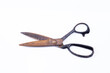 The photo shows an old rusty scissors on white background
