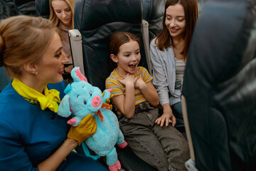 Wall Mural - Happy child celebrating birthday with mother and stewardess in plane