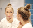 © lado2016 - Woman looking in the mirror Applying the cream..Magic anti-aging cream.