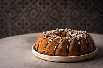 Wall Mural - Vanilla bundt cake with chocolate glaze and nuts on top