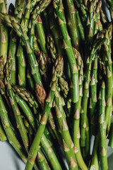 Canvas Print - green asparagus stalks ready to be roasted in white dish