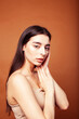 © iordani - cute happy young indian woman in studio closeup smiling on brown background, fashion beauty lifestyle people concept