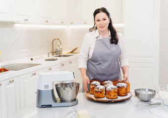 Wall Mural - female cook with Kraffins, easter cakes and Panettones in the kitchen.