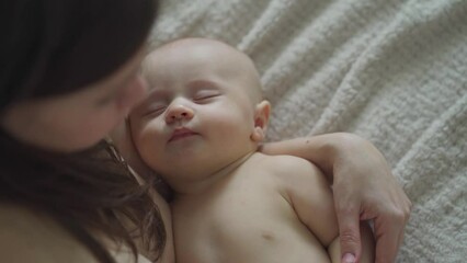 Sticker - a beautiful naked baby sleeps in his mother's arms. the happiness of motherhood.