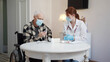 © iaginzburg - A pharmacist is talking to an elderly patient and talking about one of the coronovirus vaccines