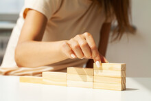 Woman Hand Stacking Wooden Blocks In Shape Of Staircase.