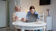 © iaginzburg - An old woman and her adult granddaughter do paperwork and use a laptop