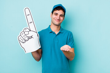 Wall Mural - handsome hispanic man smiling happily with friendly and  offering and showing a concept. number one hand fan concept