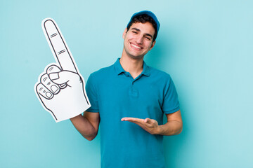 Wall Mural - handsome hispanic man smiling cheerfully, feeling happy and showing a concept. number one hand fan concept