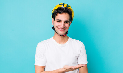 Wall Mural - handsome hispanic man smiling cheerfully, feeling happy and showing a concept. bike concept