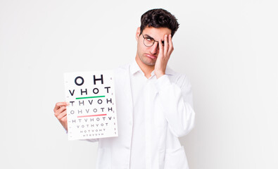 Wall Mural - handsome hispanic man feeling bored, frustrated and sleepy after a tiresome. optical vision test concept