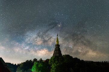 Wall Mural - the milky way galaxy moving over a sacred temple at doi inthanon national park, chiang mai, thailand