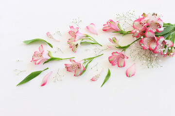 Wall Mural - Top view image of pink and purple flowers composition over wooden white background .Flat lay