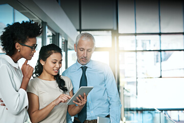 Poster - Using technology to take brainstorming to the next level. Shot of a business team using a digital tablet while having an informal meeting.