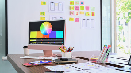 Wall Mural - modern computer with color swatches and wireframe sketches for mobile application on wooden table.
