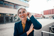 © Westend61 - Cheerful businesswoman with hand in hair at office park