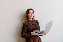 Woman Holding Laptop Standing Against White Background