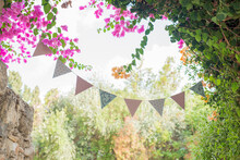 Pennants Are Placed On Colorful Flowers, Decorative Party Pennants, Colorful Pennants For Celebrations, Bunting And Garlands, Carnival Garland With Flags. Decorative Colorful Party Pennants