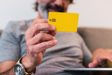 Man Using Credit Card For Paying Financial Bills At Home