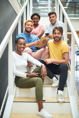 Poster - The perfect blend of different business skills. Portrait of a group of confident young businesspeople sitting on the steps of a modern office.
