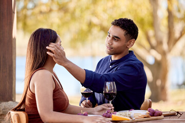 Canvas Print - Sitting next to her is always the best seat in the house. Shot of a young couple having wine on a date on a wine farm.