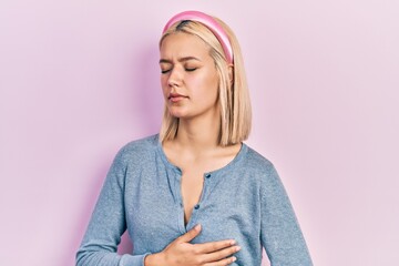 Sticker - Beautiful blonde woman standing over pink background with hand on stomach because indigestion, painful illness feeling unwell. ache concept.