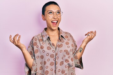 Sticker - Beautiful hispanic woman with short hair wearing glasses crazy and mad shouting and yelling with aggressive expression and arms raised. frustration concept.