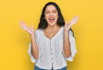 Wall Mural - Brunette young woman wearing casual clothes celebrating mad and crazy for success with arms raised and closed eyes screaming excited. winner concept