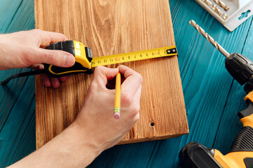 Handyman in blue uniform works with electricity automatic screwdriver.